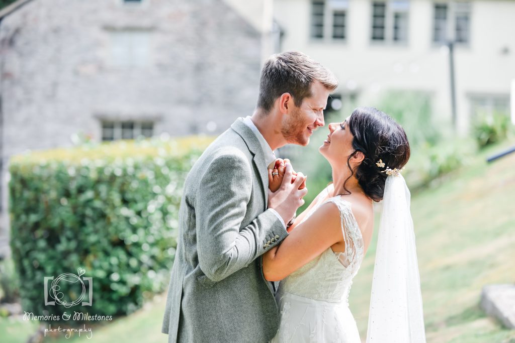 Bride and groom holing hands in a close embrace at Bickley Mill