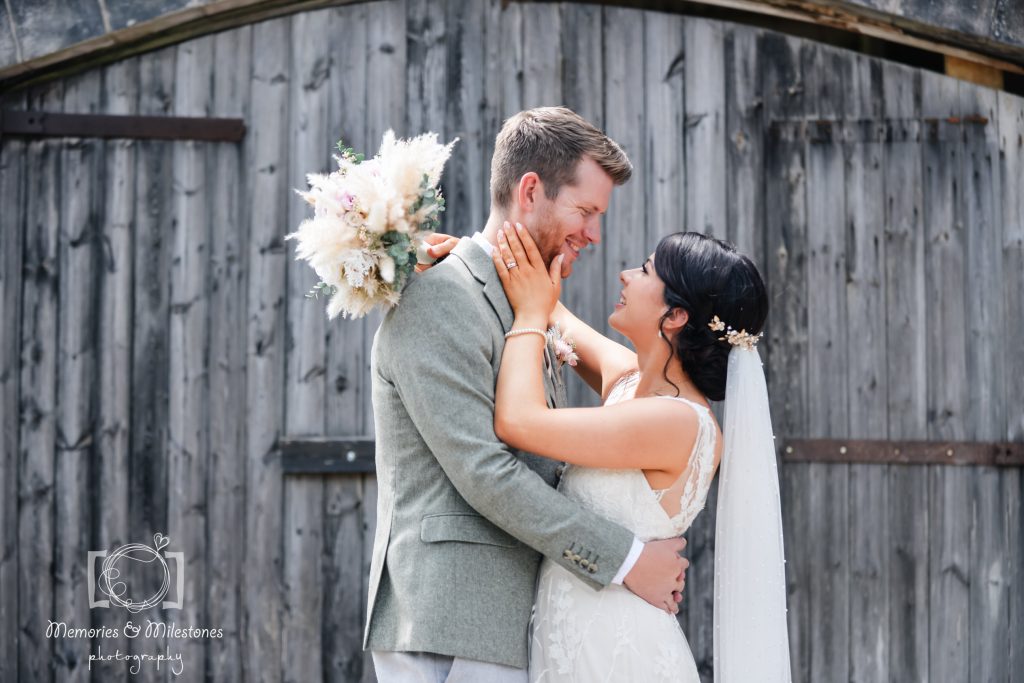 Couple in front of rustic barn at Bickley Mill