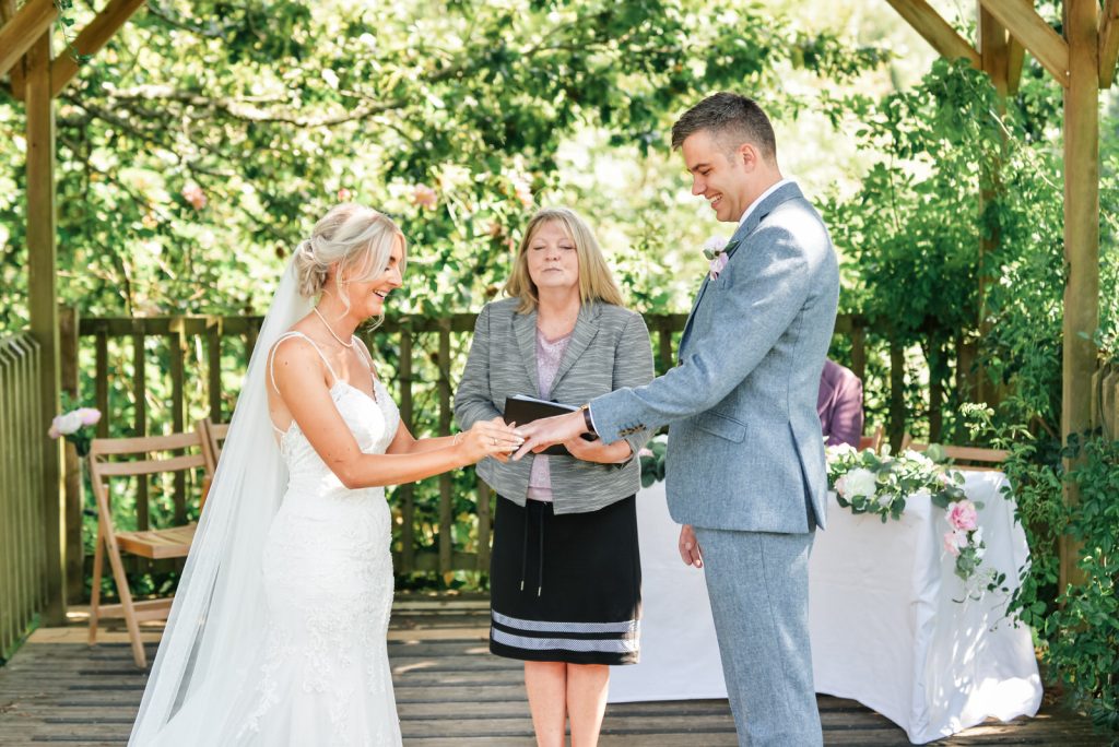 Outdoor ceremony couple exchanging rings at The Green Cornwall captured by Memories &amp; Milestones Photography