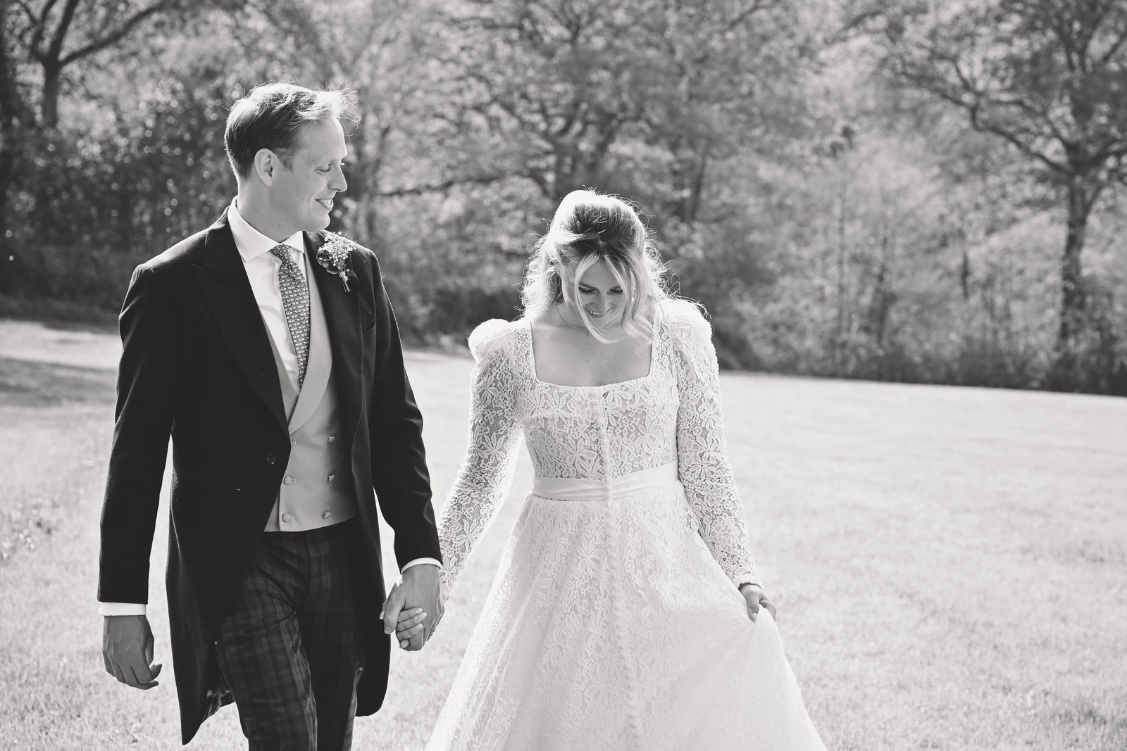 Couple walking hand in hand in the countryside captured by Memories & Milestones Hampshire wedding photographer